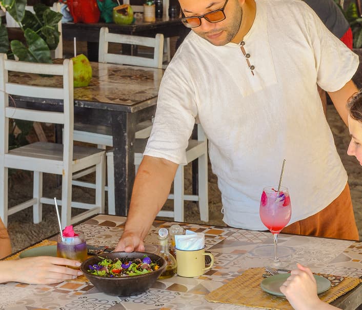 Garçon fazendo atendimento de uma mesa no restaurante
